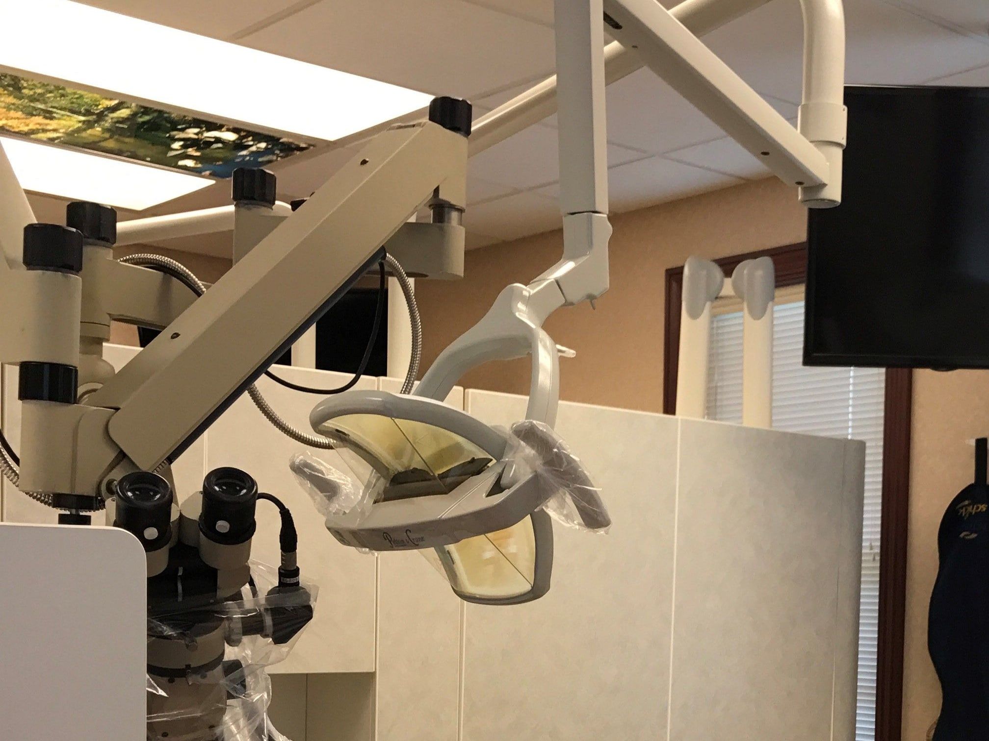 The surgical operating microscope Dr. El-Refai uses for root canal treatment, beside the dental light